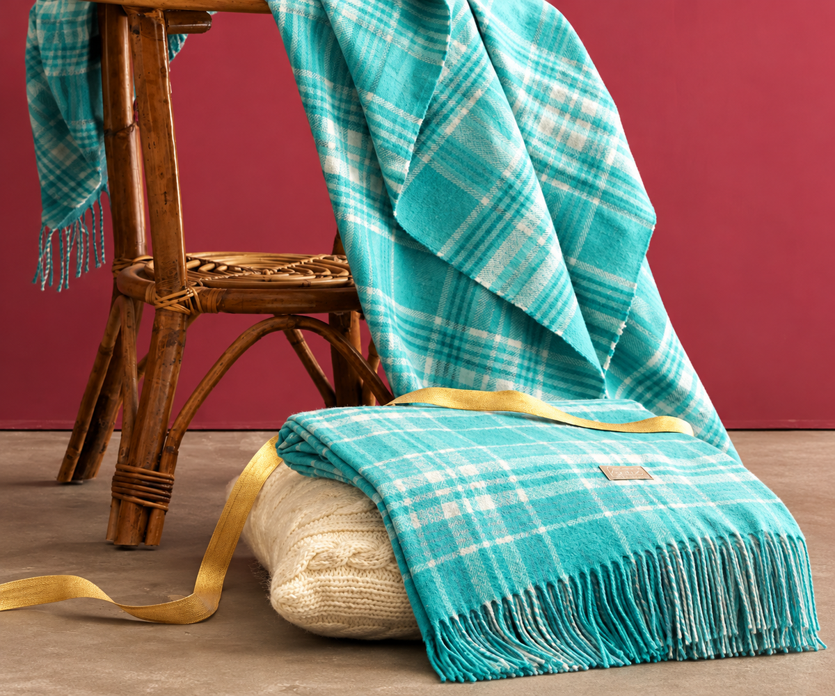 Plaid Tolosa Turchese ambientato su sedia in rattan